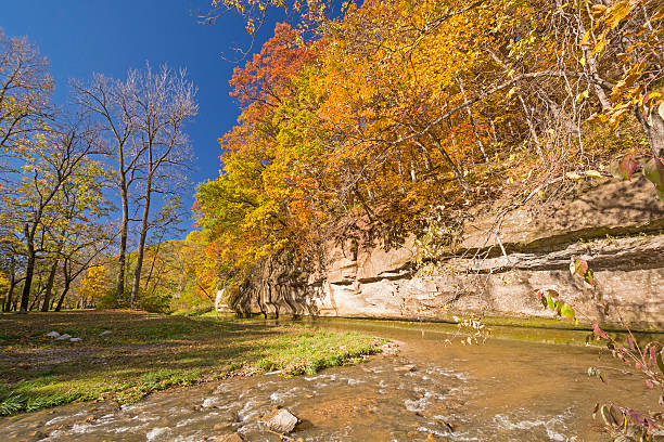 istock Fall Colors and a Limestone Cliff over a Quiet Stream. 522566561