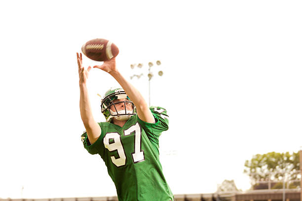 amrtican jogador de futebol americano-recebedor em acção - football player american football sports team teamwork imagens e fotografias de stock