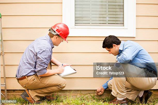 Inspectors Or Blue Collar Workers Examine Building Wall Foundation Outdoors Stock Photo - Download Image Now
