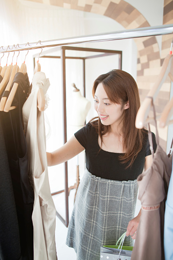 Subject: A young Japanese woman shopping for fashion and clothing in a Japanese retail Department store.