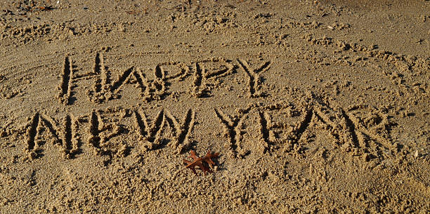 feliz año nuevo en la playa de arena - correspondence waving horizontal outdoors fotografías e imágenes de stock