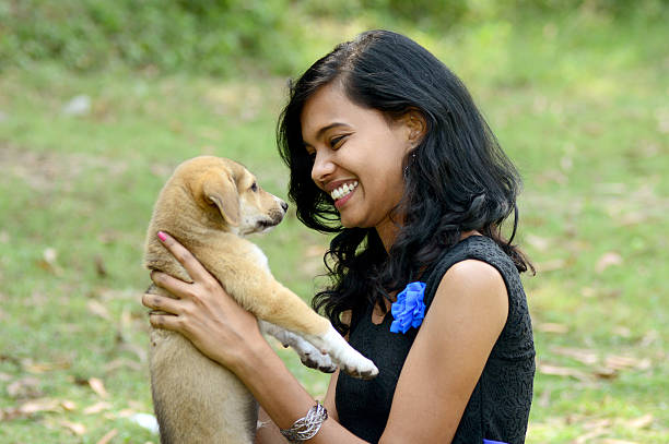 istock Young woman playing with puppy dog 522598897