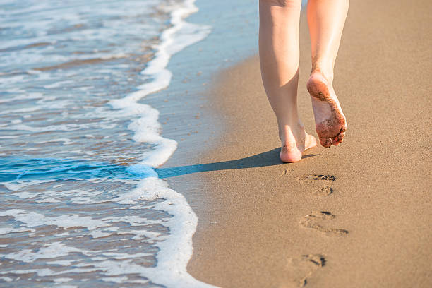 istock shapely female legs leave footprints on a sandy beach 522601711
