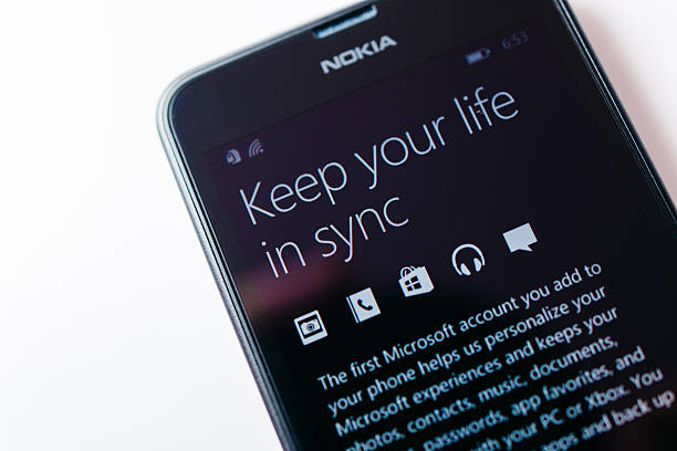 Nokia Lumia Microsoft Widowsphone London, United Kingdom - August 24, 2014: Nokia Lumia smartphone windowsphone with Keep your life in sync message. Microsoft has announced that it will stop using Nokia branding on all future mobile phones phone nokia stock pictures, royalty-free photos & images