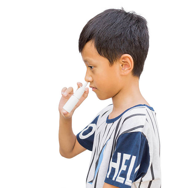 garoto segurando soro nasal garrafa com trajeto de recorte - child human nose allergy spraying - fotografias e filmes do acervo