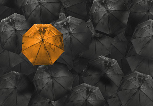 istock orange umbrella on black different business concept 522620974