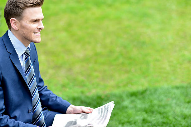 istock Businessman reading newspapers in park 522622259