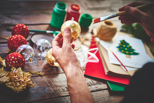 photo of human hands decorating Christmas balls