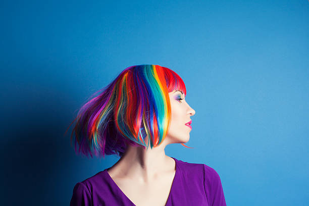 istock beautiful woman wearing colorful wig against blue background 522623607