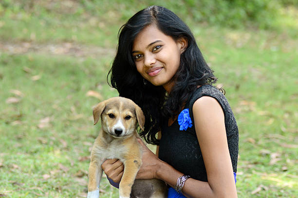 istock Young woman holding puppy dog 522623805