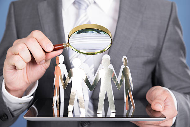 istock Holding magnifying glass and paper people 522624861
