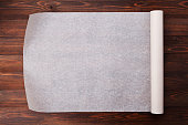 Baking paper on wooden kitchen table for menu or recipes