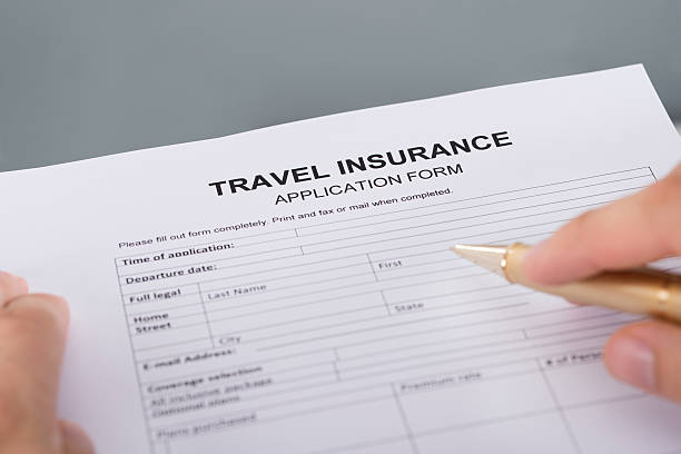 istock Hand filling travel insurance 522626327