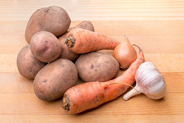 istock Potatoes, Onion, Garlic and Carrots on Wood 522627476