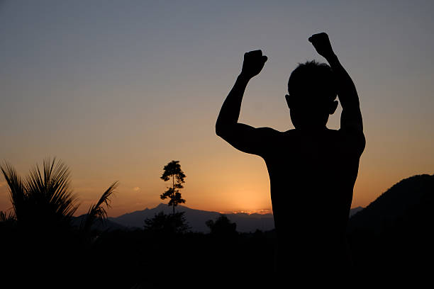 istock silhouette of Successful man with arm up. 522628294