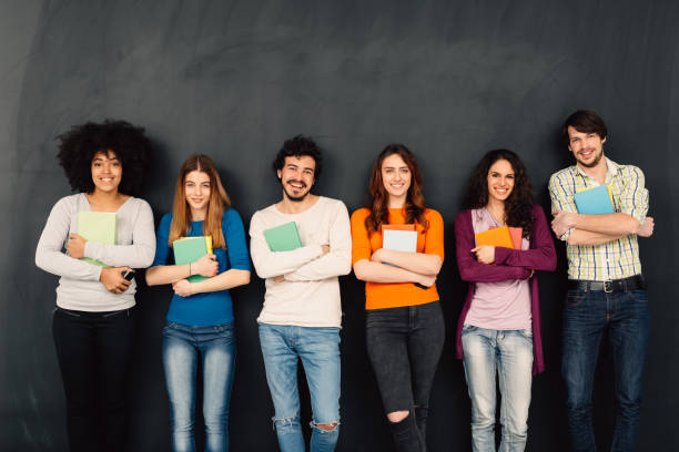 istock Friends with books in a row against blackboard 522628578