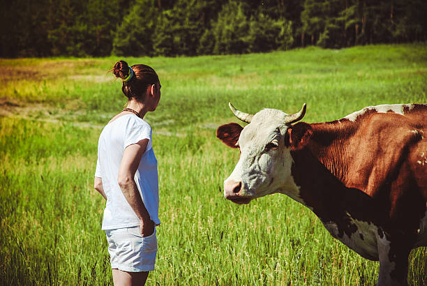 istock young woman in a field surrounded by cows 522631610