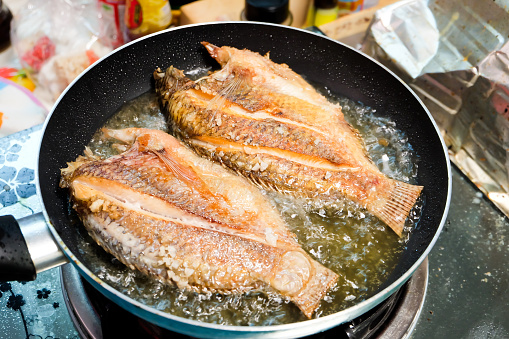 Frying fishes in frying pan 