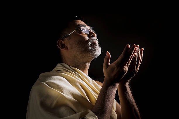 alte muslimische mann beten mit gefalteten händen - indian ethnicity sadhu india pilgrim stock-fotos und bilder