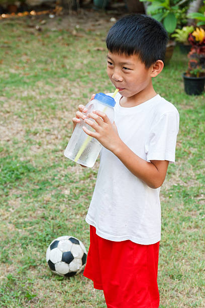 istock Thai boy drink water from bottle. 522635362