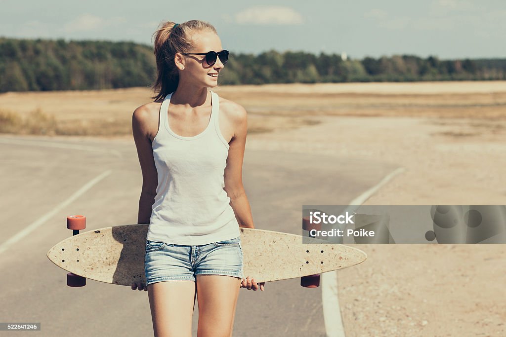 Teenage girl with skateboard Beautiful young woman with skateboard outdoors Women Stock Photo