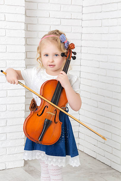 istock little girl with a violin and bow 522641686