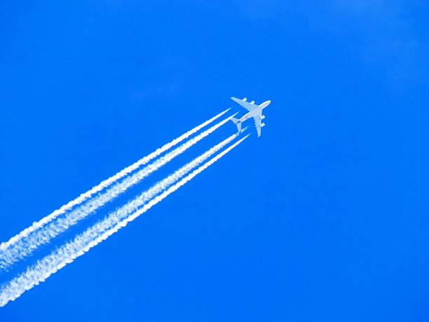 istock Airplane with chemtrails on blue sky 522642276