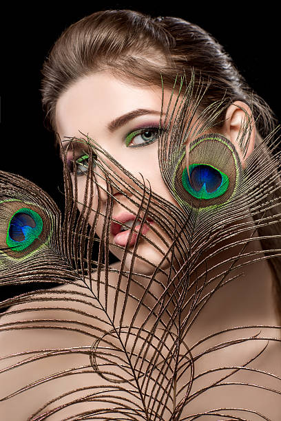 istock girl with bright  makeup and peacock feathe 522643238