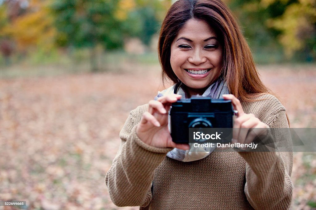 Autumn Portrait Asian woman posing outdoor in the park on a beautiful Autumn day. CAMRA Stock Photo
