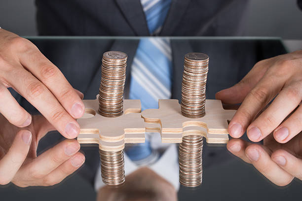istock Hands connecting puzzle pices with coins 522644747
