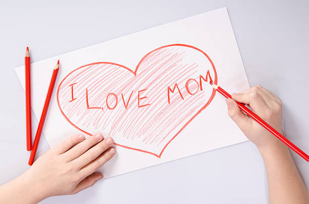 istock childs hands drawing a heart that says I love mom 522646216
