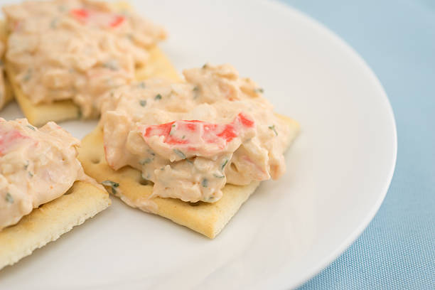 istock Lobster dip on saltine crackers on blue table cloth 522647440