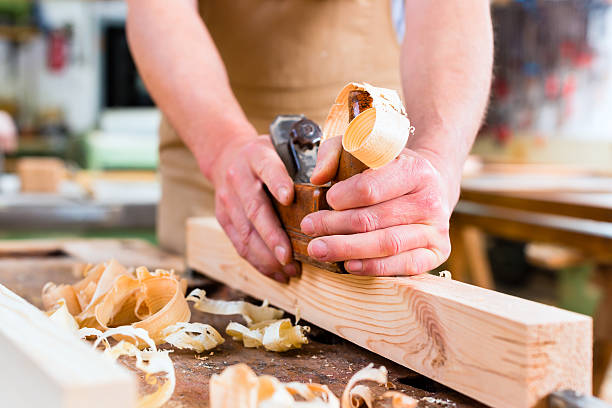 istock Carpenter with wood planer and workpiece in carpentry 522647947
