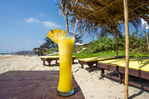 bicchiere di succo d'ananas fresco sulla spiaggia in india. - alenka foto e immagini stock