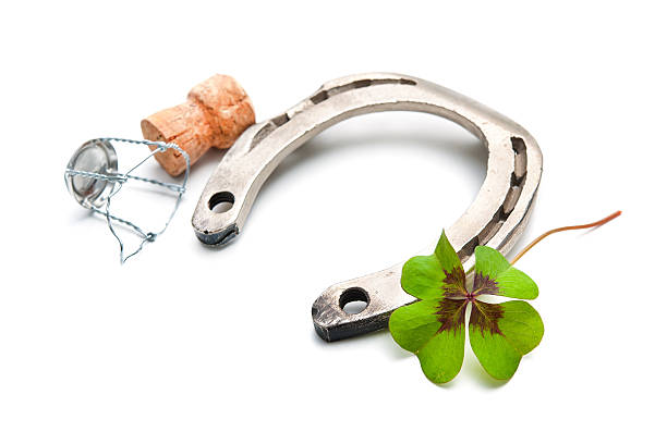 istock Horseshoe and champagne cork with a four leaf clover 522670703