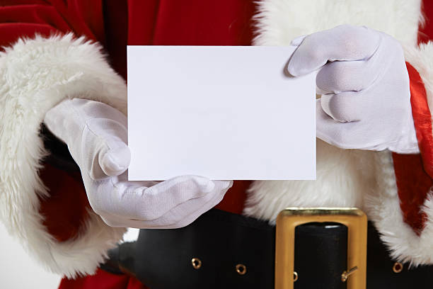 Close Up Of Santa Claus Holding Blank Invitation stock photo