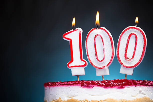 100th Birthday candles Flaming Birthday candles against dark, blue, spot  background. Canon 5D MK III number 100 stock pictures, royalty-free photos & images