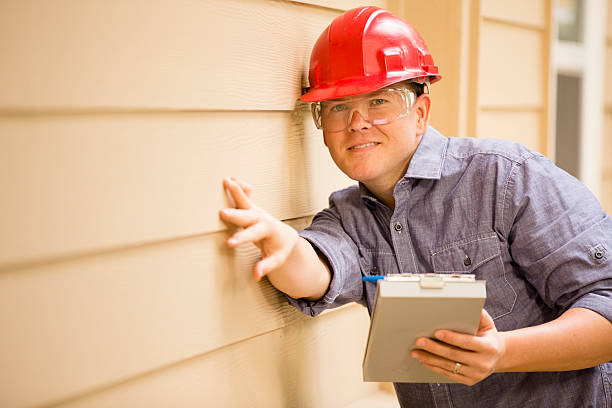 istock Inspector or blue collar worker examines building wall outdoors. 522675349