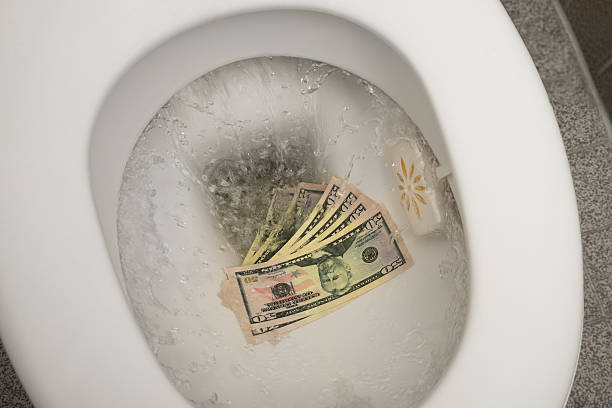 flushing money down the toilette - money down the drain stock-fotos und bilder