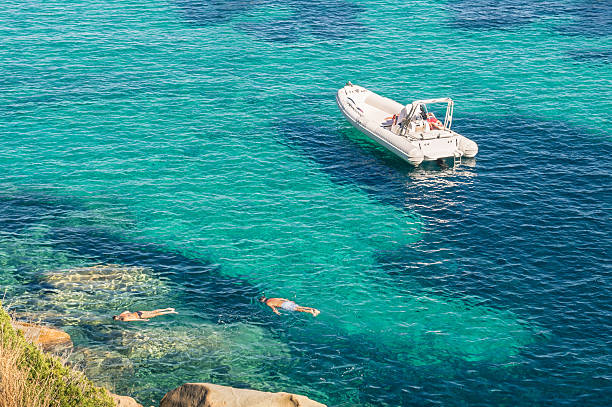 moderner luxus dinghy auf den türkisfarbenen see mit klarem blauem wasser - schlauchboot stock-fotos und bilder