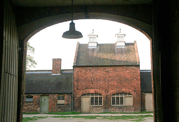 A view of the stables of Calke Abbey, UK, through an archway.