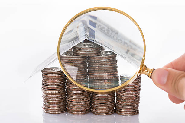 istock Inspecting house made from coins 522692491