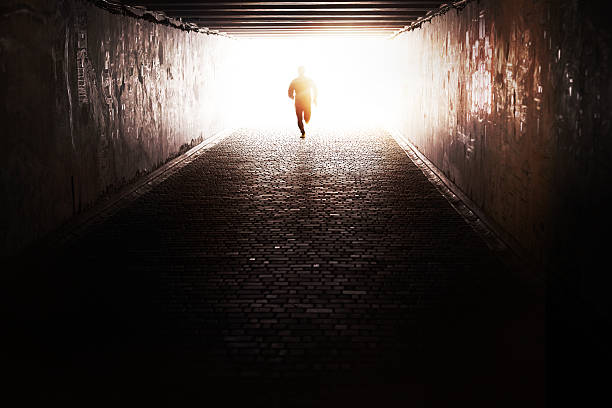 Running through the tunnel Man running through the tunnel in the sun escaping stock pictures, royalty-free photos & images