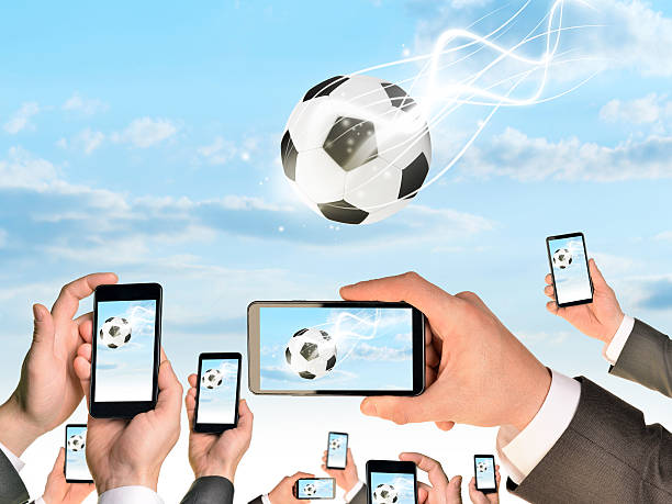 istock Hands holding smart phones and shoot video as falling soccer 522694621