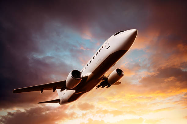 istock Airplane in the sky at sunset 522697059