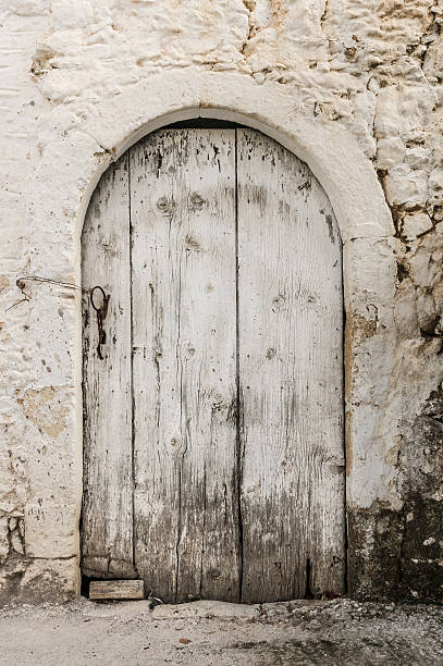 istock Old white timber door in the scuffed wall 522697539