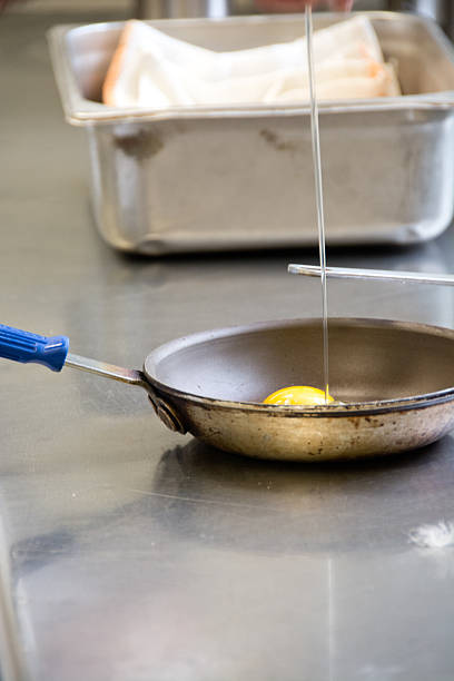 istock Breaking eggs in to a frying pan 522711387