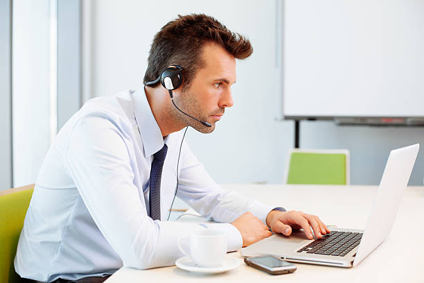 istock Busy man working on laptop with headset 522712683