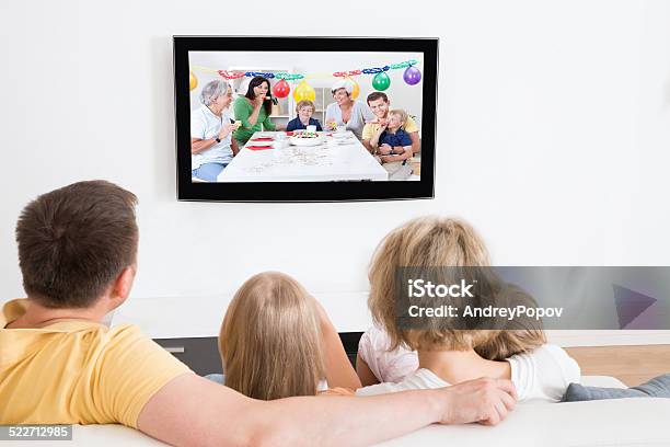 Young Family Watching Tv Together Stock Photo - Download Image Now - Adult, Casual Clothing, Child