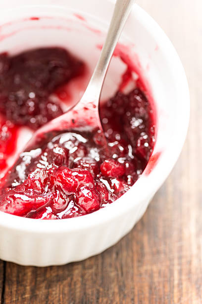 istock Cranberry sauce on wooden table close up 522716521